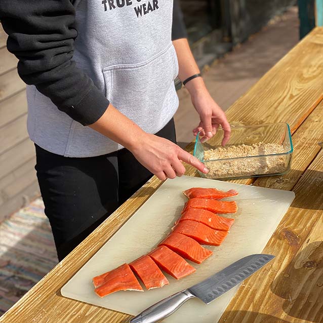 McKenna prepping salmon on a cutting board
