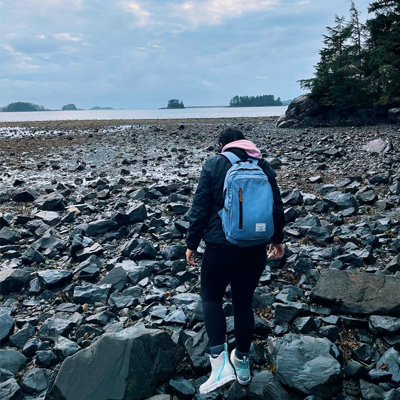 An adventurous backpacker wearing XTRATUF boots