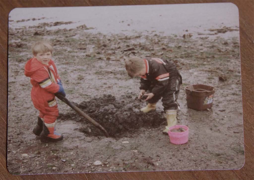 Young kids digging in the sand (vintage photo)