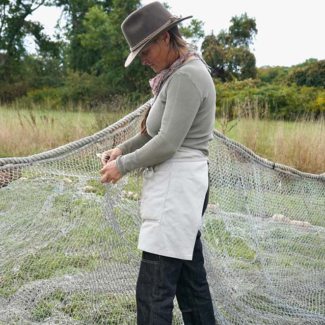 Corey fixing a hole in her fishing net