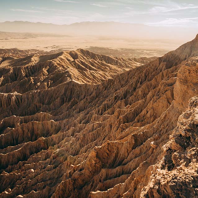 Hilly, dry, sunny dessert terrain seen from above.