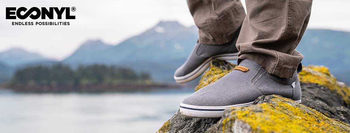 Xtratuf Econyl grey shoes standing on mossy rocks