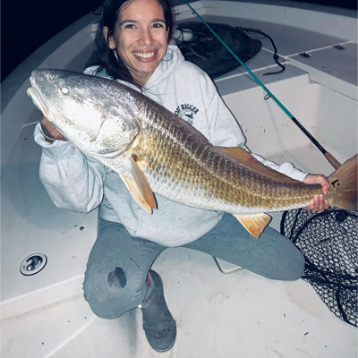 Person on boat holding a large fish
