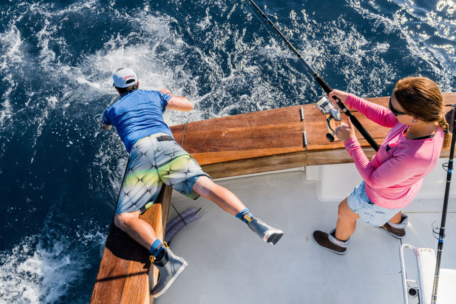 Anglers catching a sailfish while weating Xtratuf boots.