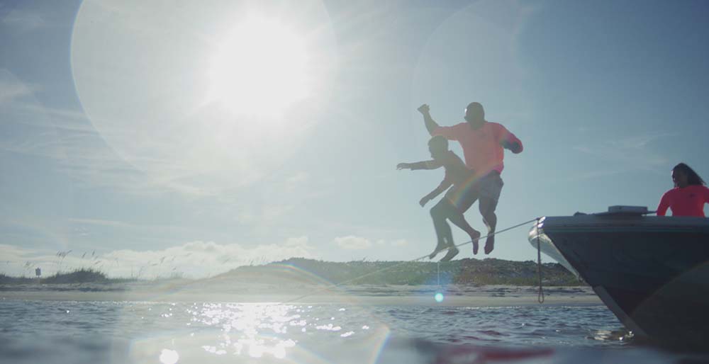 Lionel and student jumping from the boat into the water