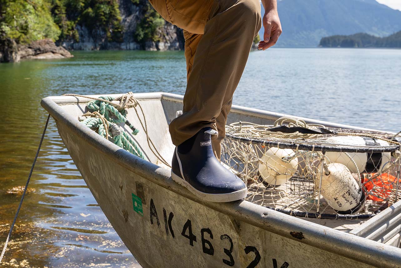 Allan on a single person fishing boat wearing his Xtratuf Ankle Deck Boots