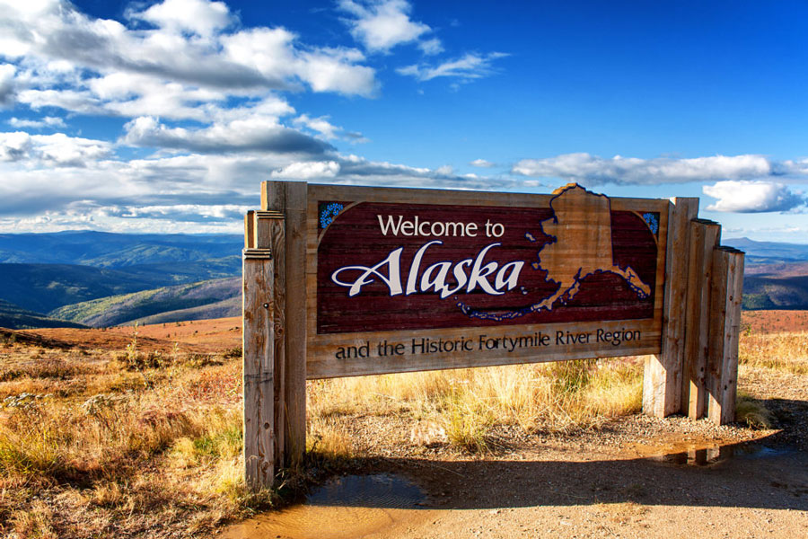 Alaska welcome sign over looking mountains. 