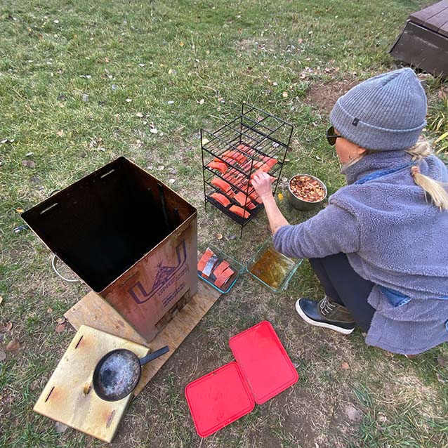 McKenna prepping to smoke the salmon, placing it on a wire rack.