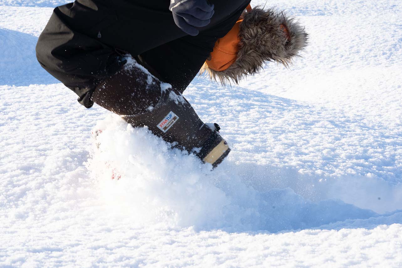 Allan walking through deep snow in his Xtratuf boots.