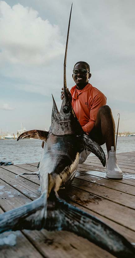 Emmanuel happily showing off his catch while back on land.