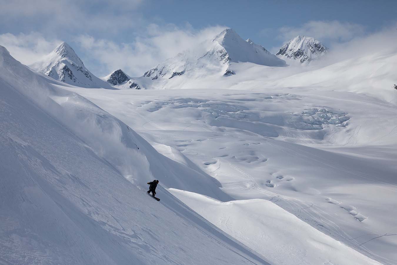 Birdseye shot of snowboarder riding on a steep mountain
